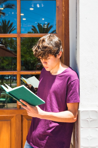 Free photo teenager reading near door