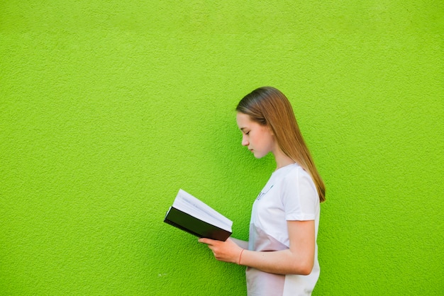 Teenager reading textbook on green