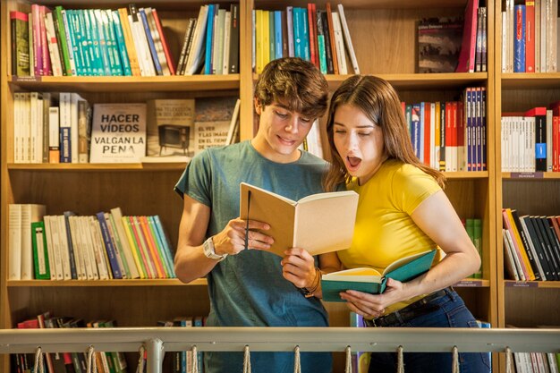 Teenager showing notebook to shocked girlfriend