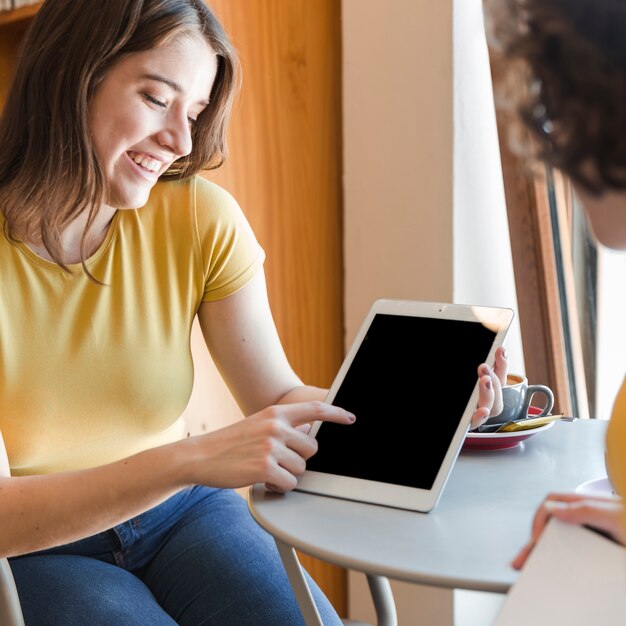 Teenager showing tablet to friend