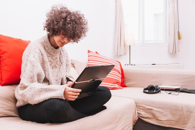 Teenager using laptop on sofa