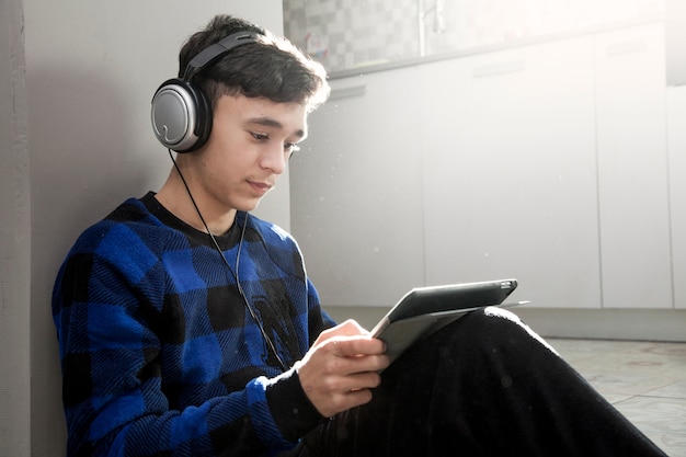 Free photo teenager using tablet of floor