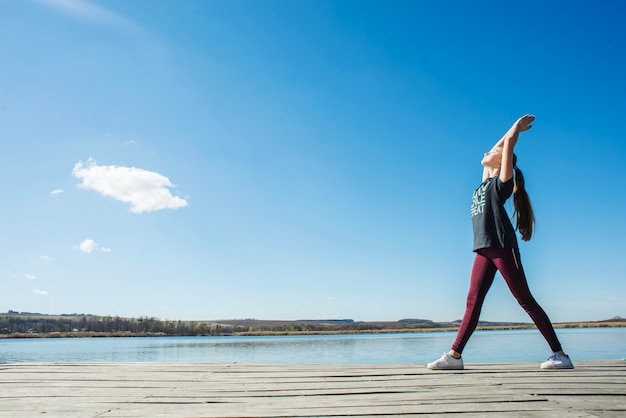 Teenager in warrior position on pier