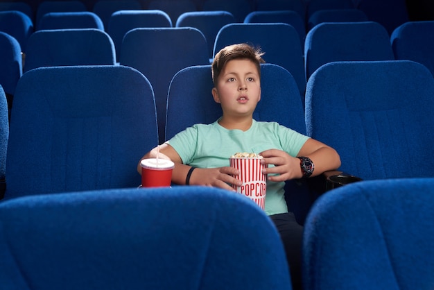 Teenager watching movie in cinema theatre.