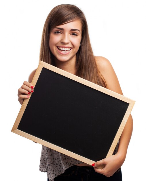 Foto gratuita adolescente con un grande sorriso in posa con una lavagna