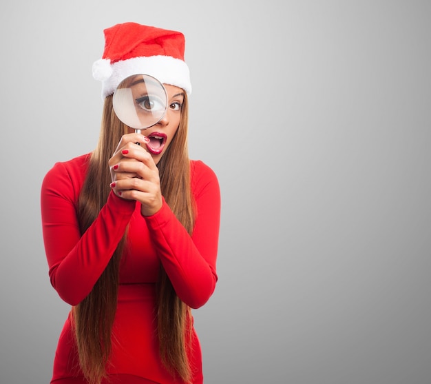 Teenager with red dress using a magnifying glass