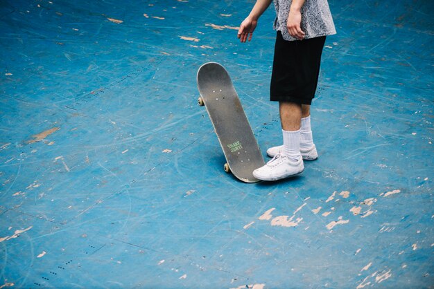 Teenager with skateboard on bottom of bowl