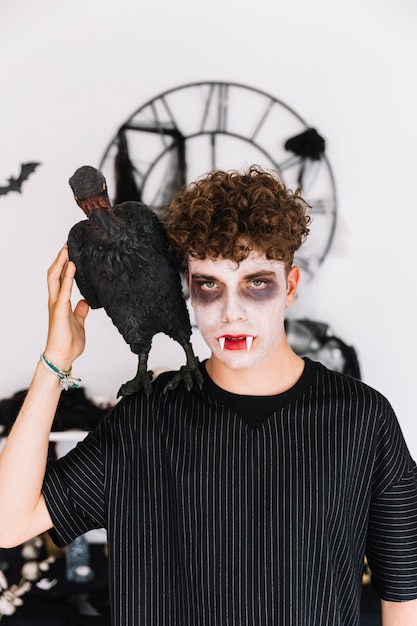 Teenager with vampire grim and raven on shoulder