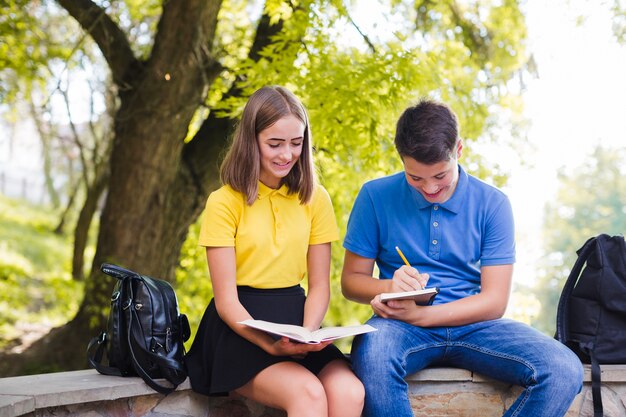 Teenagers doing homework in park