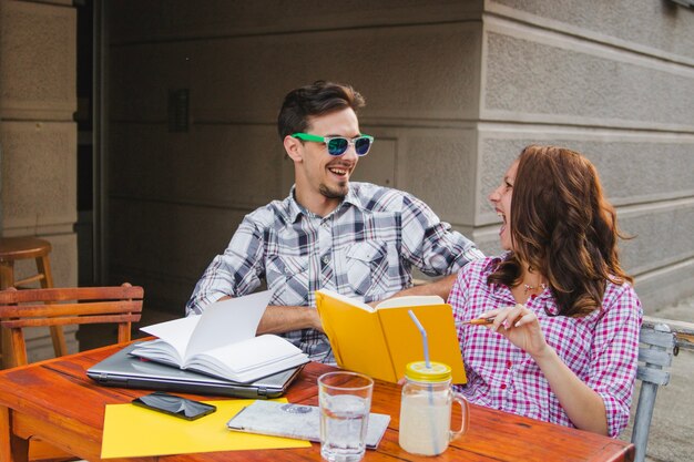 Teenagers laughing while posing with books