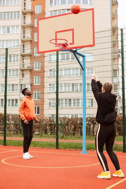 Teenagers playing basketball outdoors