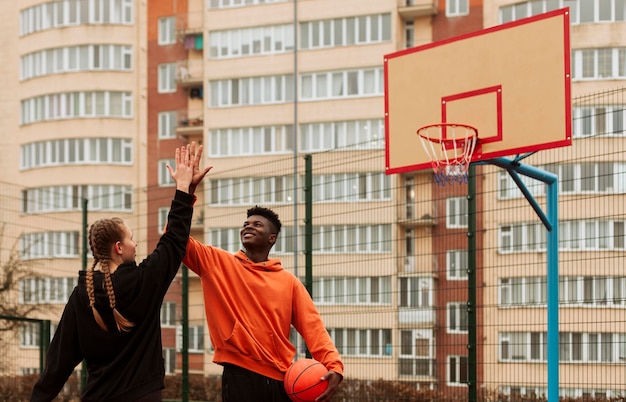 Free photo teenagers playing basketball outdoors