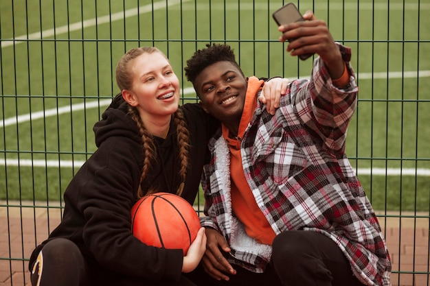 Free photo teenagers posing at the basketball field