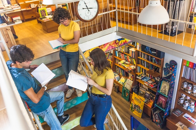 Free photo teenagers reading textbooks on stairway