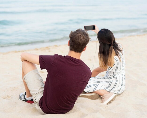 Teenagers taking a selfie together at the beach