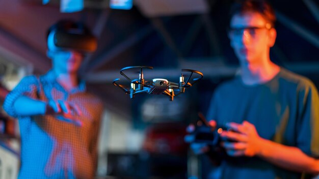 Teens doing experiments in robotics in a laboratory Boy in protective glasses and guy in VR headset