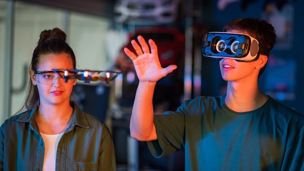 Foto gratuita ragazzi che fanno esperimenti di robotica in un laboratorio ragazzo con visore vr che tiene in mano un piccolo drone