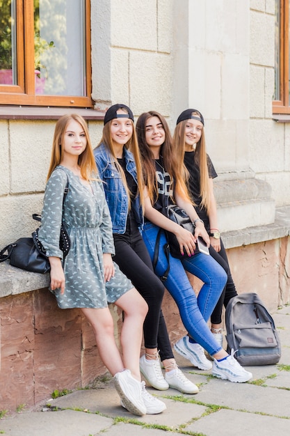 Teens leaning on building