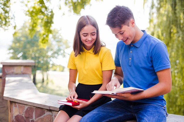 Teens reading books in park