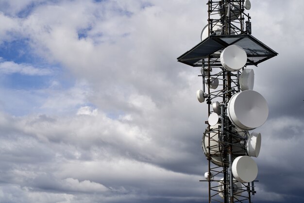 Telecommunications towers against cloudy sky