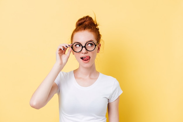 Tempting ginger woman in eyeglasses licking her lips