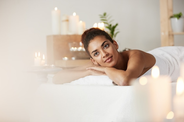 Tender african woman resting relaxing in spa salon.