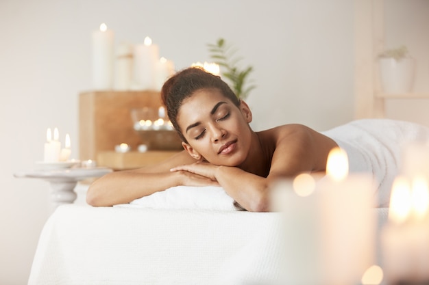 Tender african woman resting relaxing in spa salon.