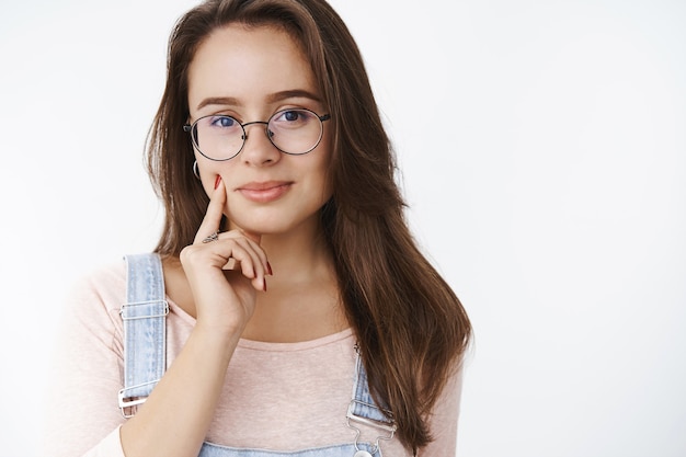 Tender attractive and sensual young brunette woman in transparent glasses feeling confident
