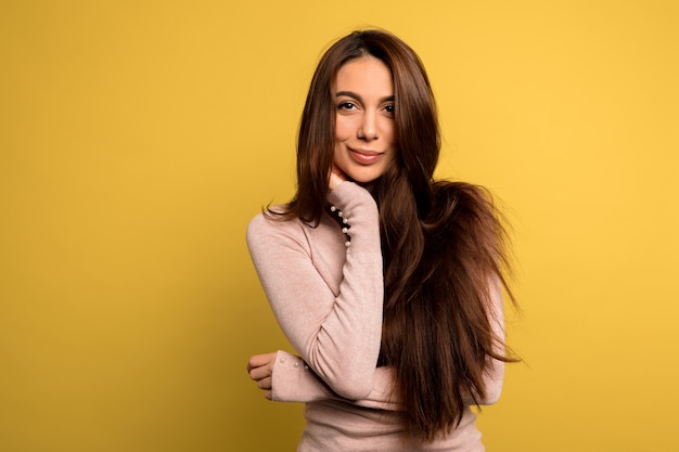 tender beautiful girl with dark hair wearing pink shirt posing Studio shot of blissful brunette woman.