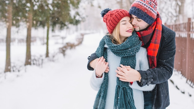 Tender embracing couple in snowfall