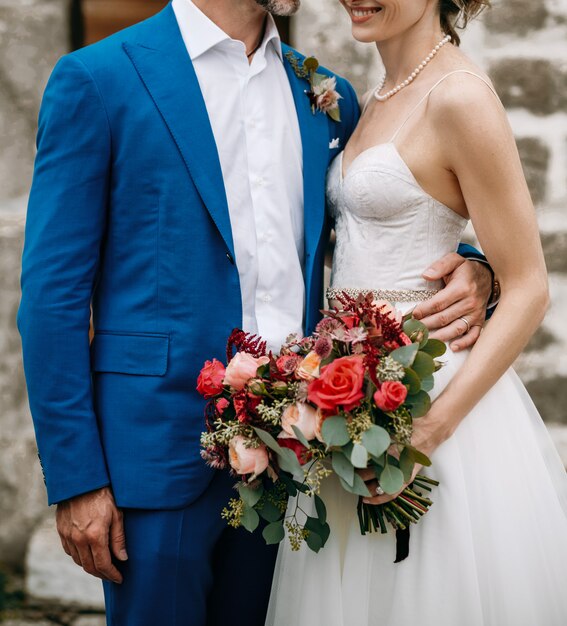 Tender hugs of charming wedding couple standing outside