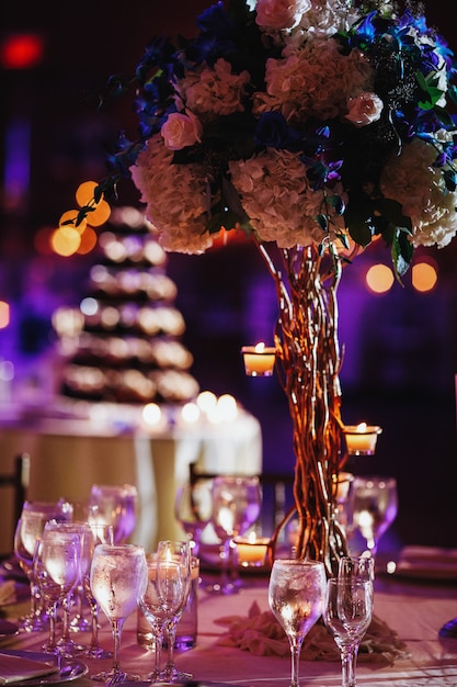 Tender hydrangea centerpiece and wine glasses on blurred background