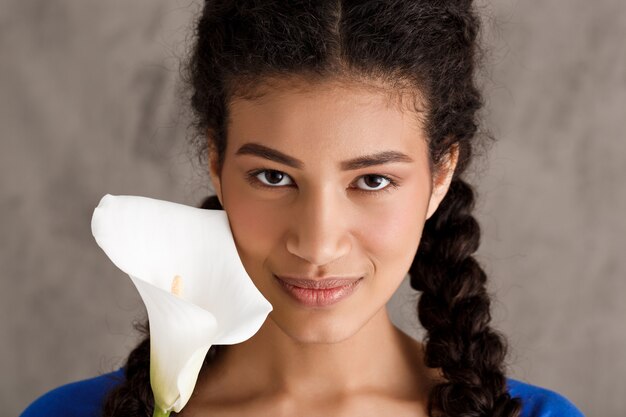 Tender smiling teenage woman holding flower