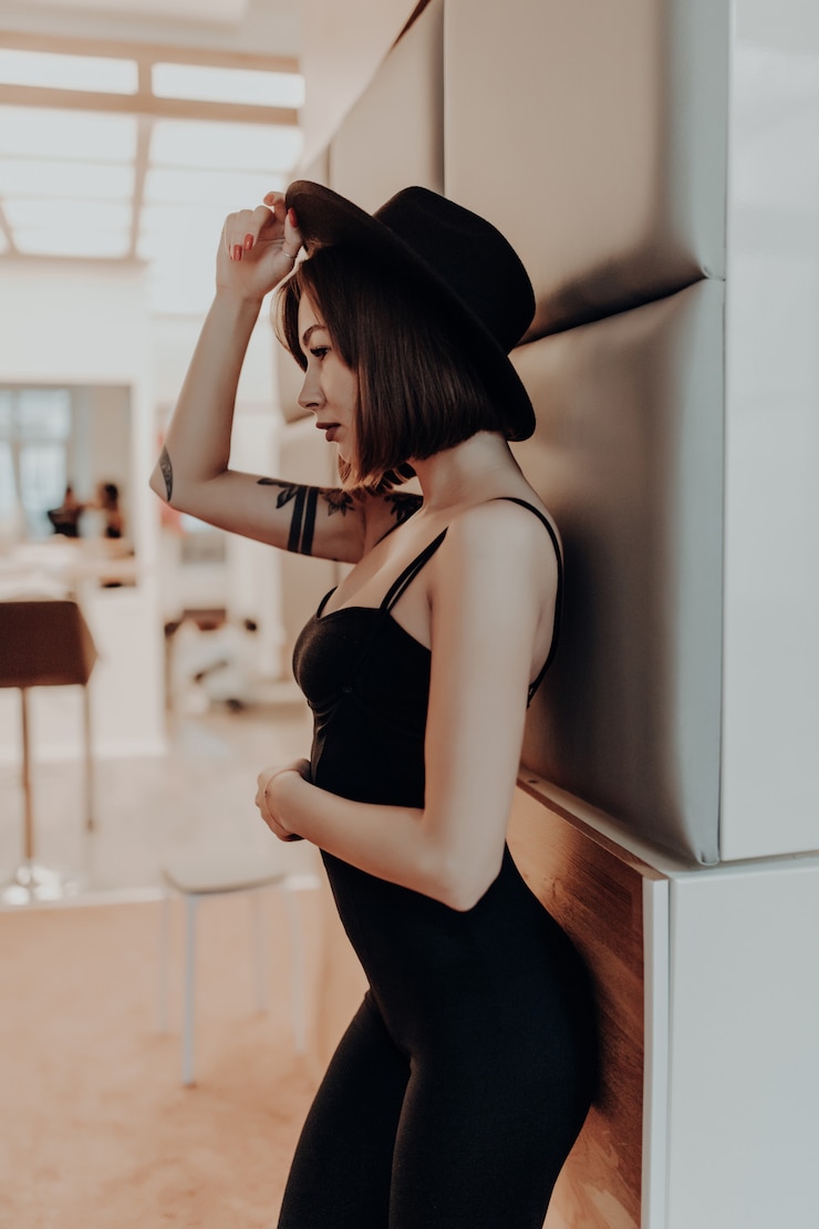 무료 Photo 고급 아파트에서 벽 근처에 검은 드레스와 모자 서 부드러운 여자 성인 갈색 머리 여자