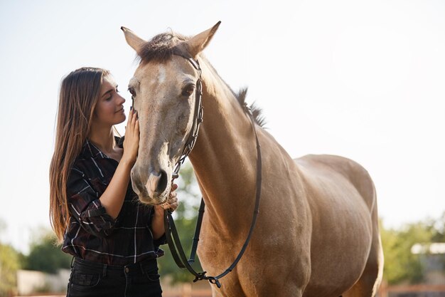 Tenderness animals and friendship concept Pretty female jockey