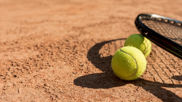 Tennis balls and black racket