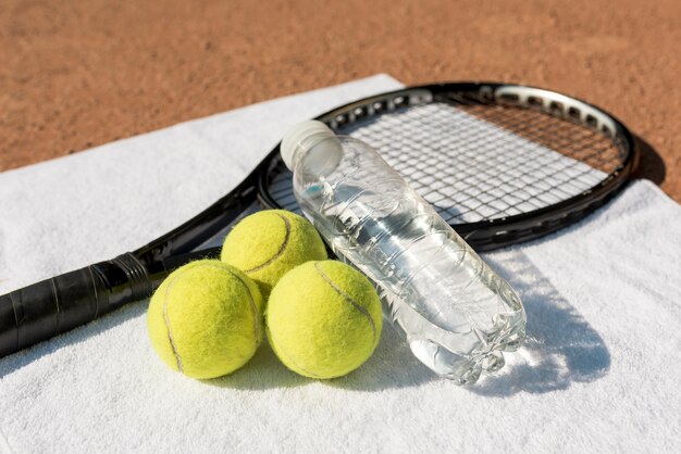 Tennis balls and black racket