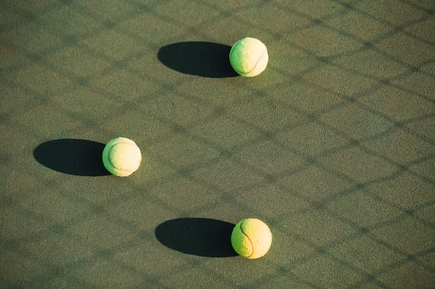 Foto gratuita sfere di tennis sul campo da tennis e sull'ombra netta