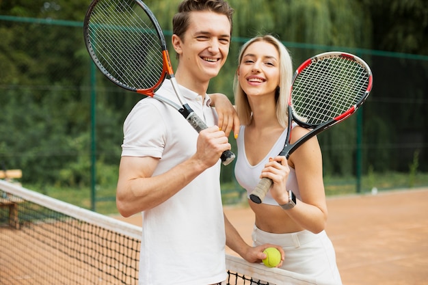 Tennis couple with rackets posing