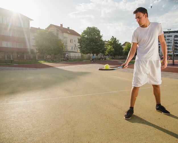 Tennis player balancing ball on racket