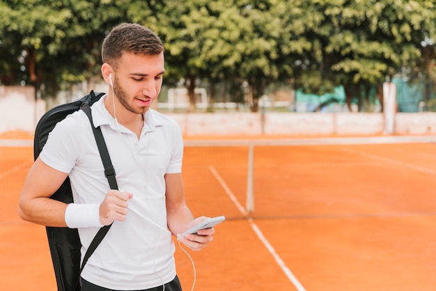 Free photo tennis player holding a smartphone