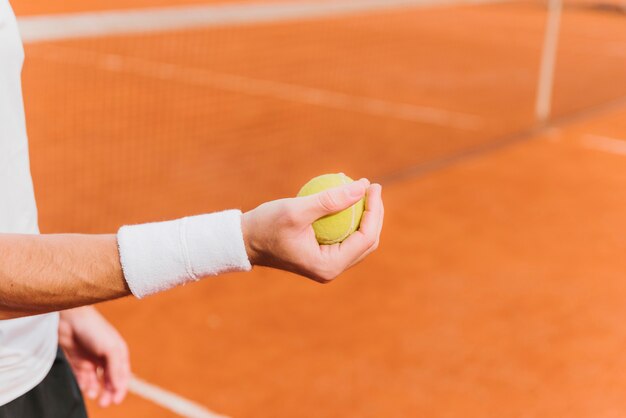 Tennis che tiene pallina da tennis