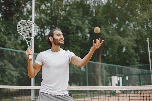 Foto gratuita uomo del giocatore di tennis concentrato durante il gioco