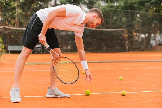 Free photo tennis player taking a ball