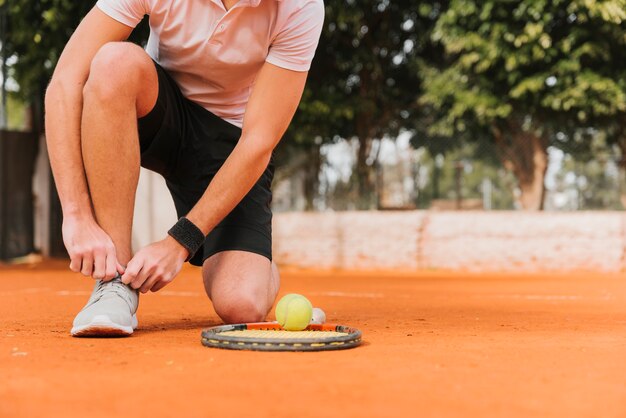 Tennis player tying his shoelaces