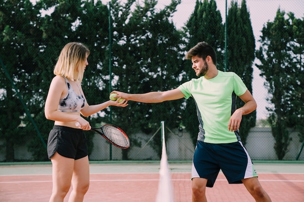 Tennis players interchanging ball