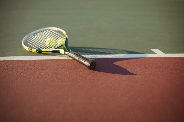 Tennis racket and balls on court