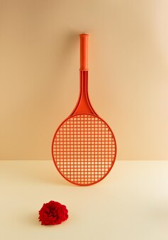 A tennis racket and a red rose like a ball minimal sport concept
