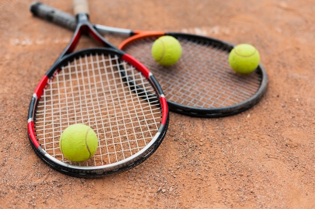 Tennis rackets with balls on the court Free Photo