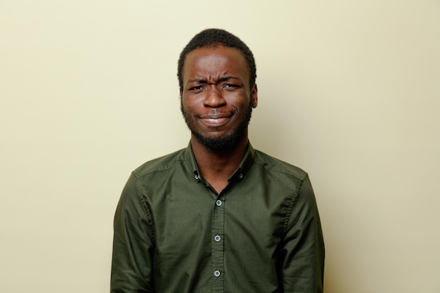 Tense young african american male wearing green shirt isoloated on white background